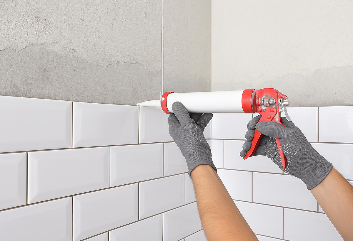 Απεικονιζεται συγκολληση πλακιδιων σε τοιχο με τη χρηση της μαστίχης.